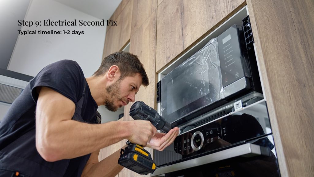 Electrician installing a cooker in a new kitchen
